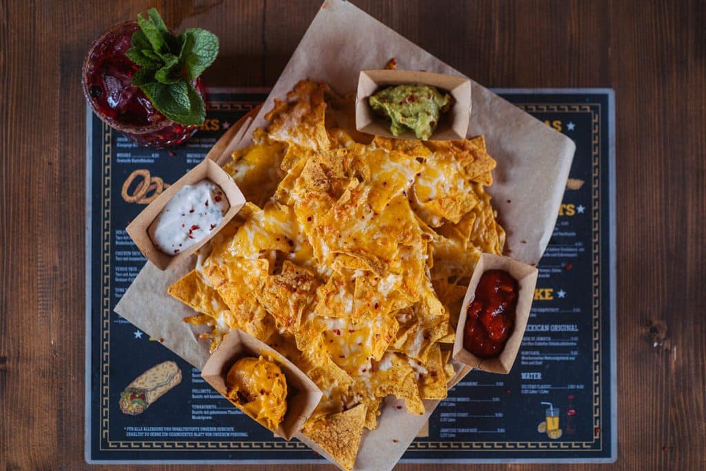 Nachos mit Käse überbacken und vier verschiedenen Dips